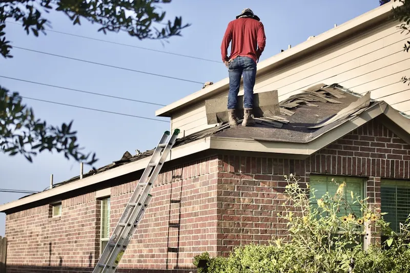Professional roofer working on a residential roof in Franklin Field South